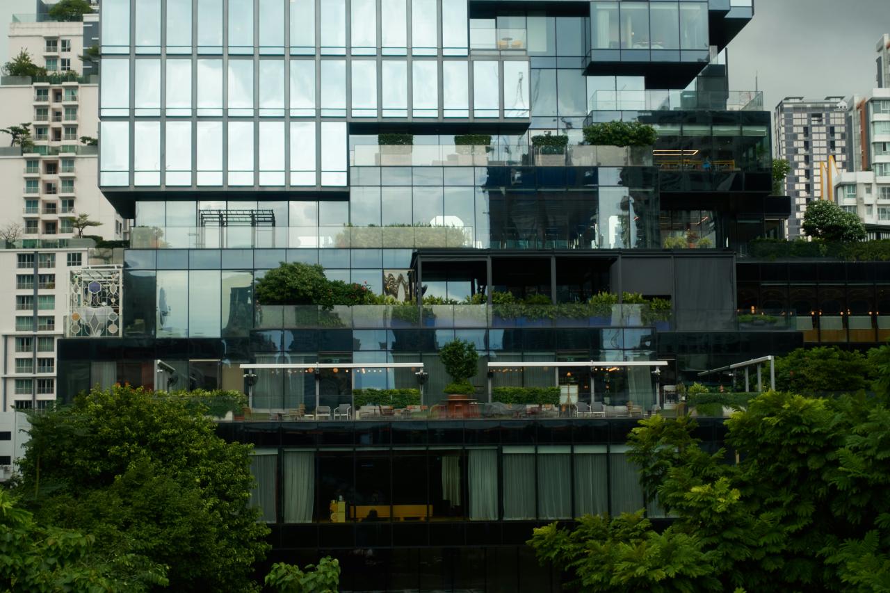 Modern building with glass facade and green terraces