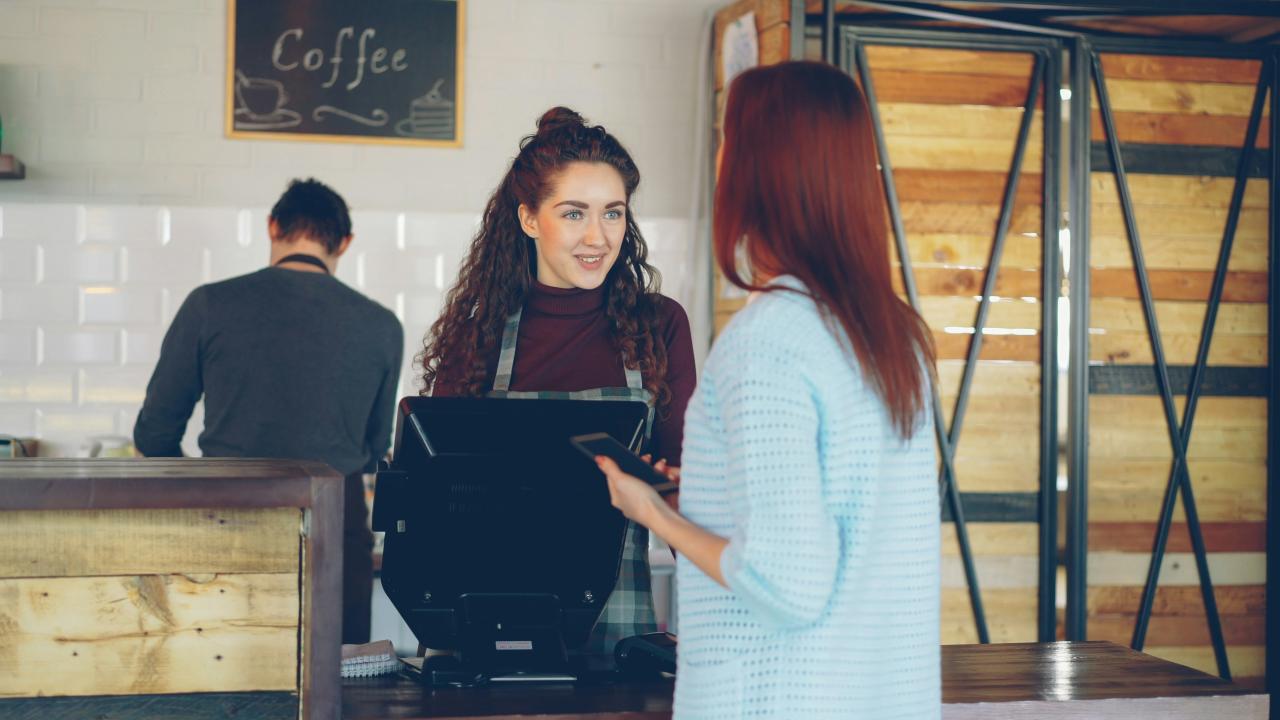 Customer pays with card at a cafe.